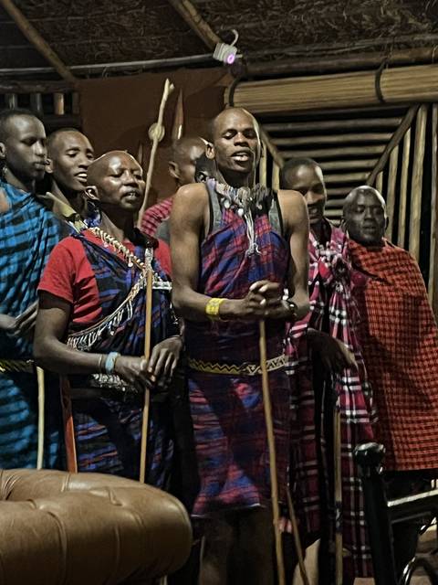       Group of people indoors with traditional attire and musical instruments.
  