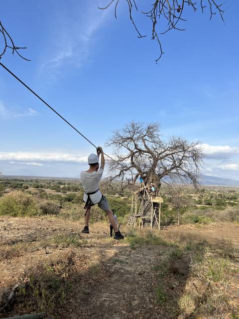       Person using a zipline in a rural landscape.
  