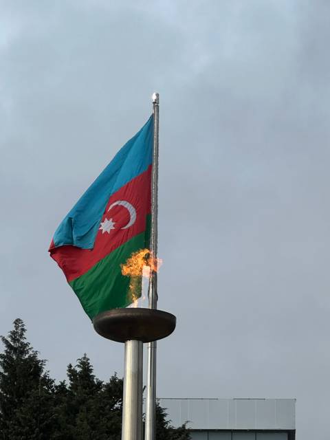       Azerbaijan flag with an eternal flame.
  