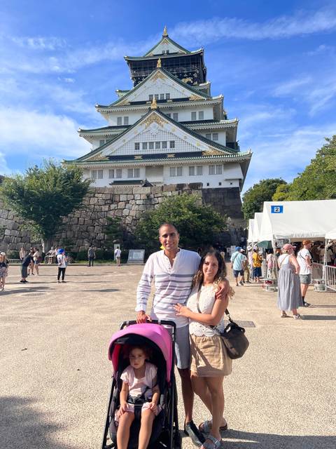 Family posing in front of a famous Japanese castle.