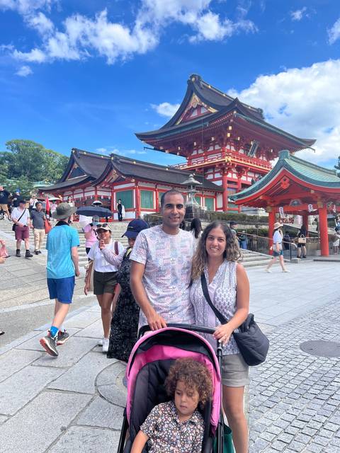 Family posing in front of a traditional Japanese shrine.