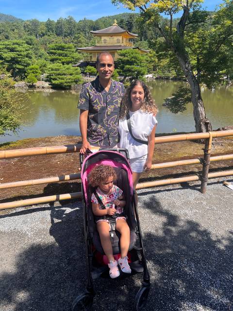 Family visiting a famous Japanese temple near a pond.