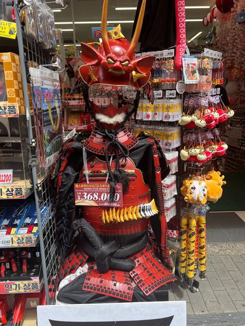       A display of traditional Japanese armor and decorations in a store.
  