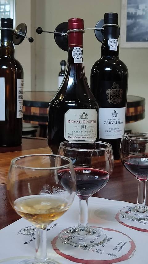       Several bottles of port wine with glasses in a tasting setting.
  