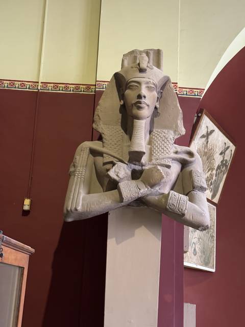       Ancient Egyptian statue inside a museum.
  