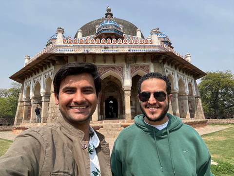       Two people standing in front of a historical building.
  