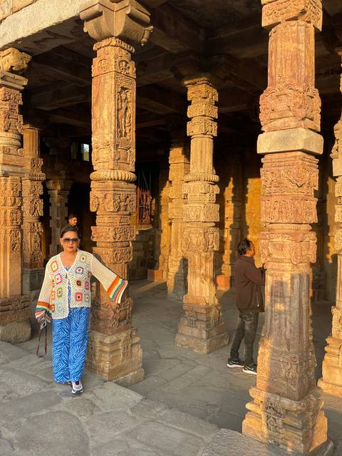       Person standing with detailed stone pillars.
  