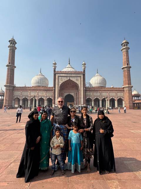       Family posing in front of a mosque.
  