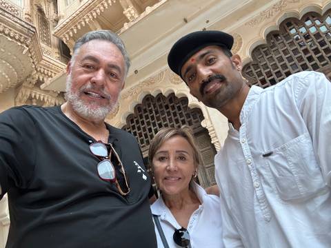       Three people posing at a cultural landmark.
  