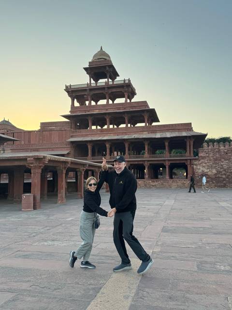       Couple posing with a historic building in the background.
  