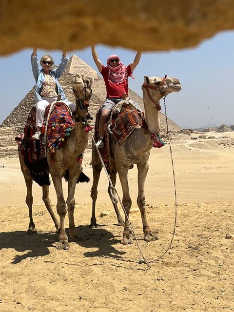       People riding camels in the desert
  
