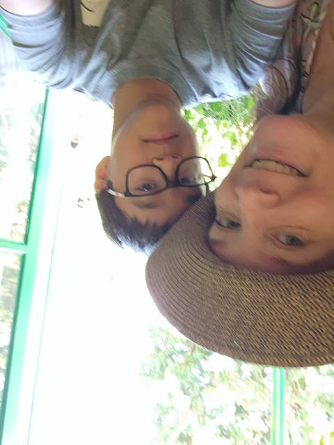 Two people, one wearing a straw hat, posing for a photo.