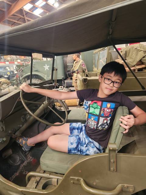 Child posing in a vintage military vehicle.