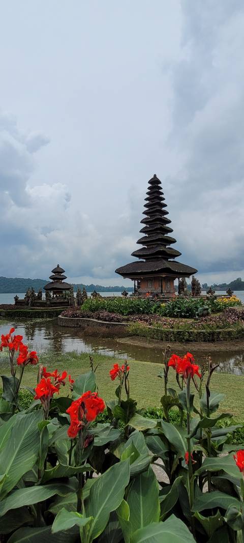 A pagoda-style temple surrounded by a beautiful garden and water.
