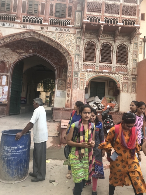       Group of people outside an entrance with intricate carvings.
  