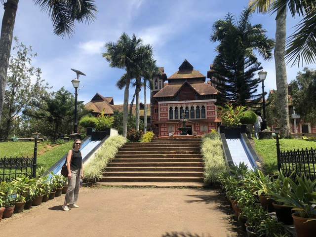 Colorful building with gardens and palm trees.