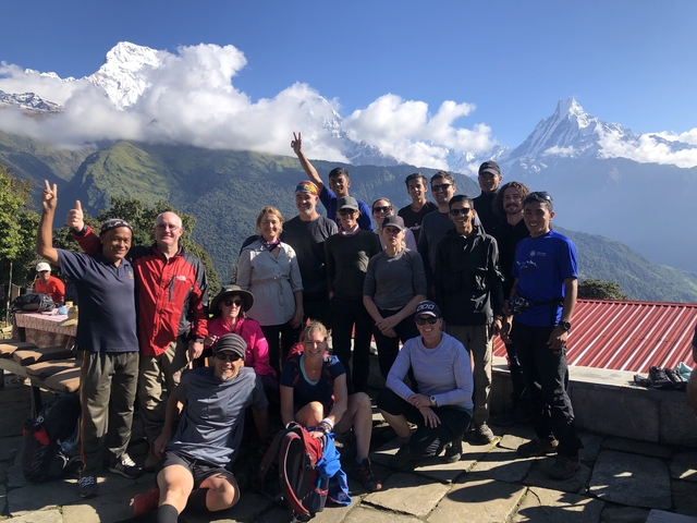 A group of people posing with mountains in the background.