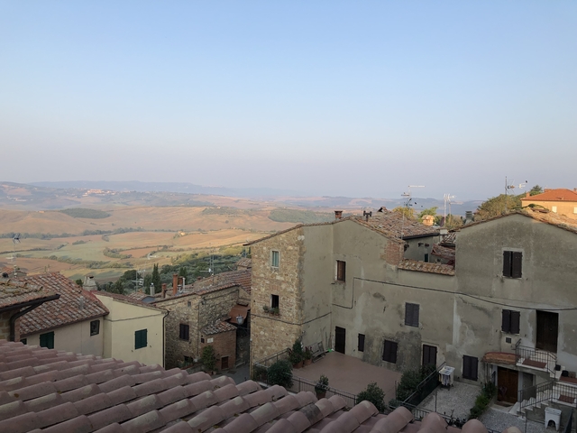       Rooftops of an Italian village with rolling hills in the distance.
  