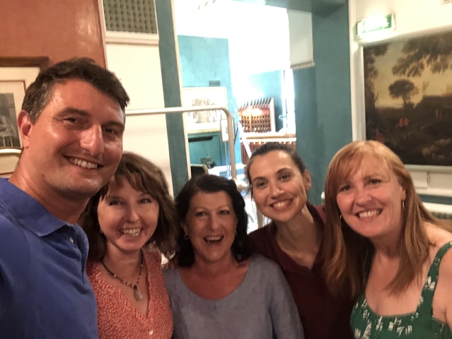       Group of people posing indoors, smiling.
  