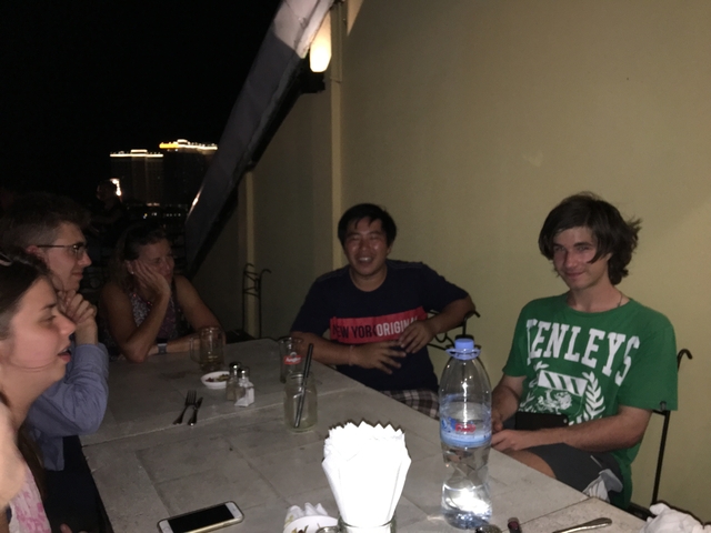 Group of people sitting at a table at night.
