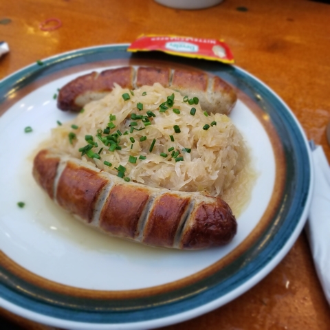 Traditional sausages with sauerkraut on a plate.