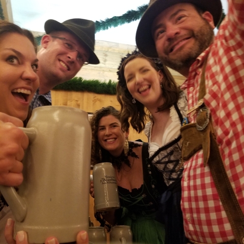 Group selfie with beer steins, showing motion blur.