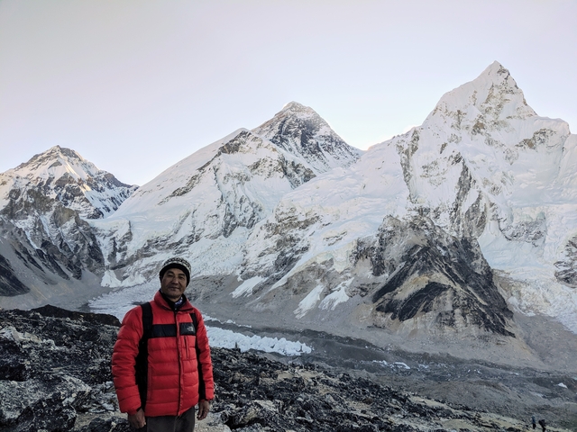 Man posing with Himalayas in the background.