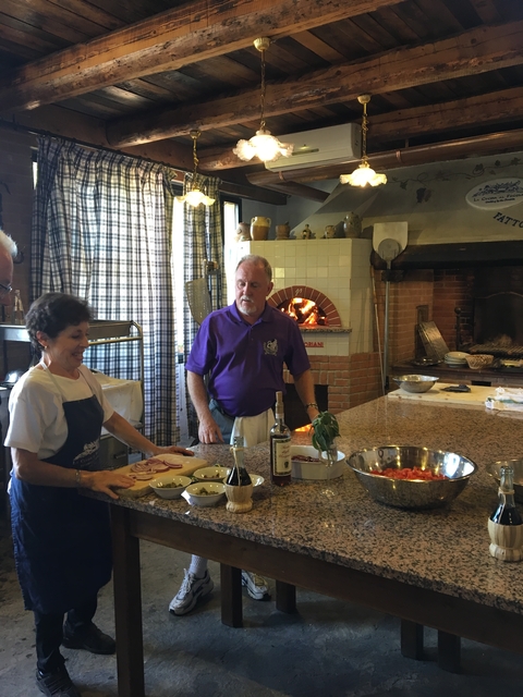       People preparing food in a rustic kitchen.
  