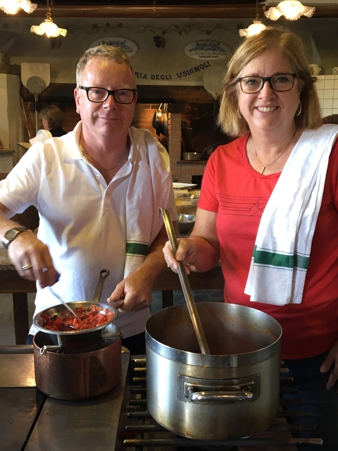       Two people cooking together.
  