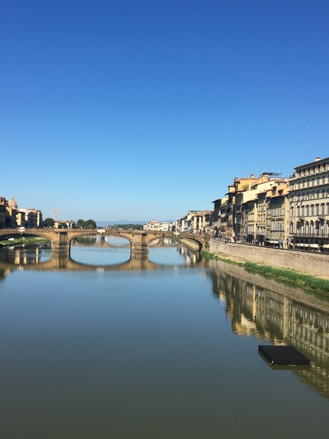       Bridge over a calm river reflecting the cityscape.
  