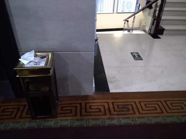 Trash bin and sign in a corridor.