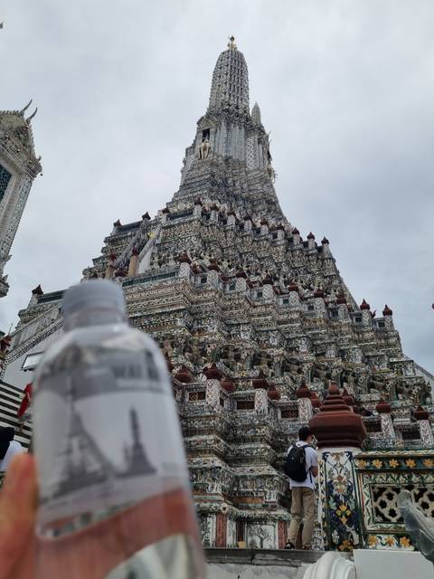 The Wat Arun temple with a bottle in the foreground.