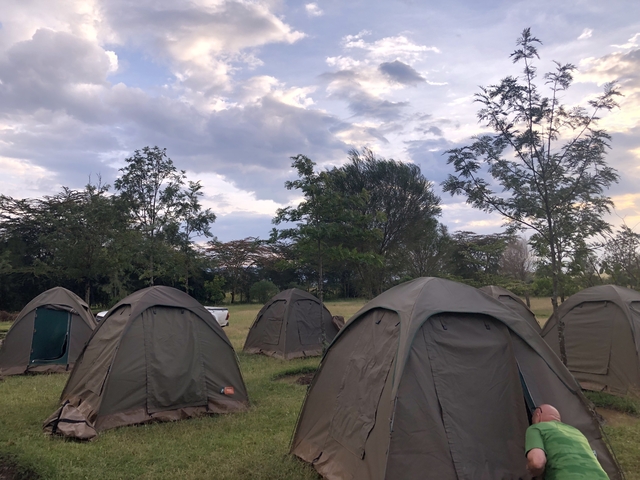 Campsite with several tents under a cloudy sky.