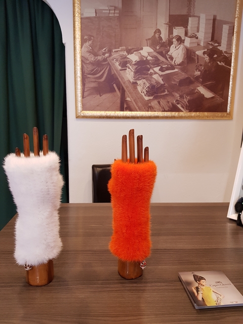       Wooden mannequin hands with furry coverings displayed on a table.
  