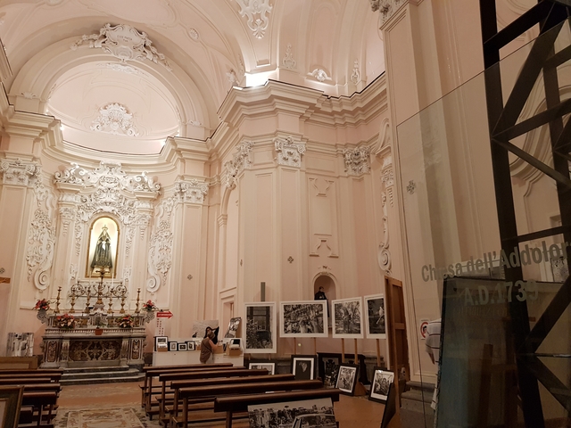       Ornate church interior with religious icons and photographs.
  