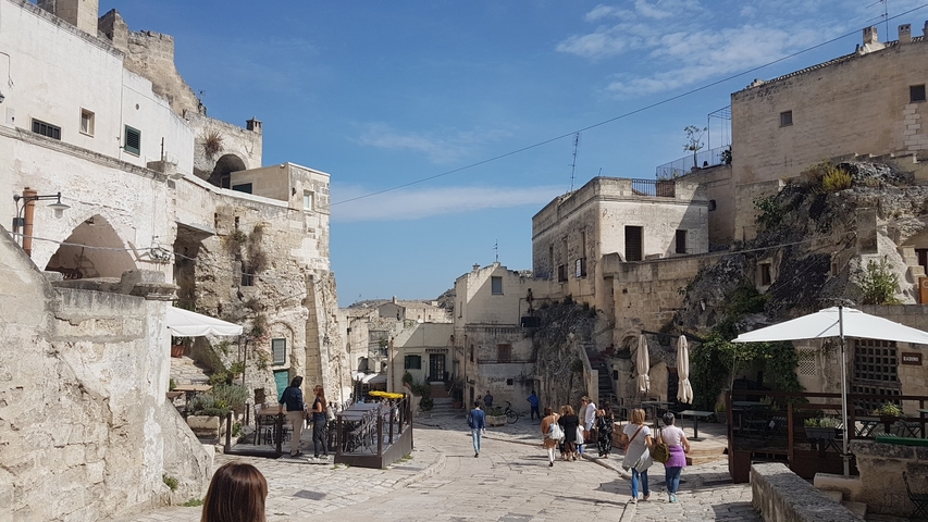       Historic town setting with people exploring.
  