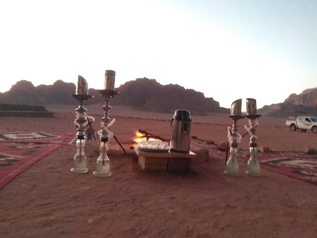       Outdoor setup with hookahs and mountains in Wadi Rum.
  