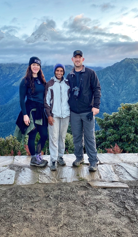Two tourists with a local guide on a mountain.