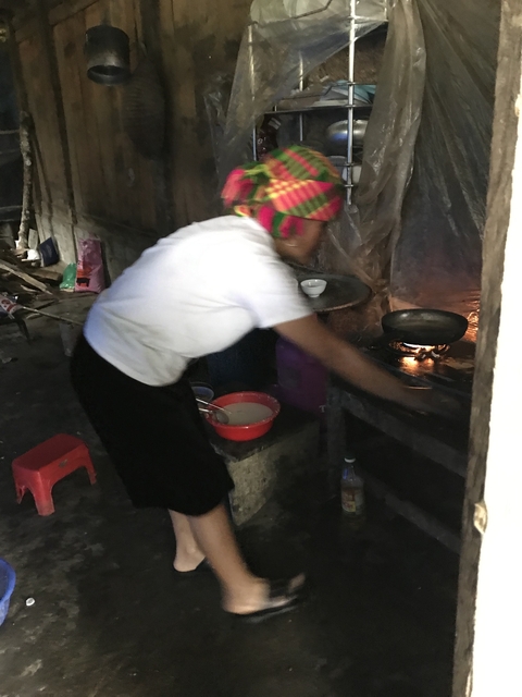 Person cooking in a rural kitchen setting.