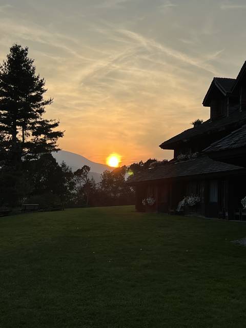 Sun setting over a landscape with trees.