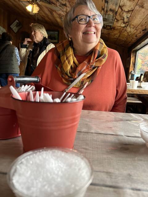       Smiling woman at a table with a drink.
  