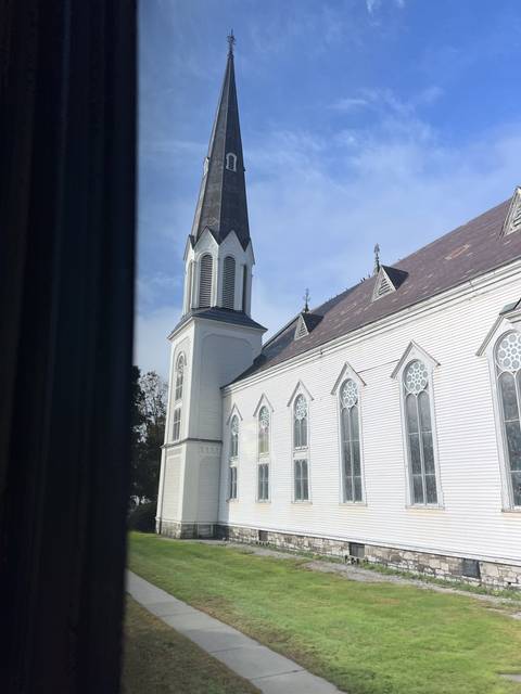 A white church building with a tall steeple.