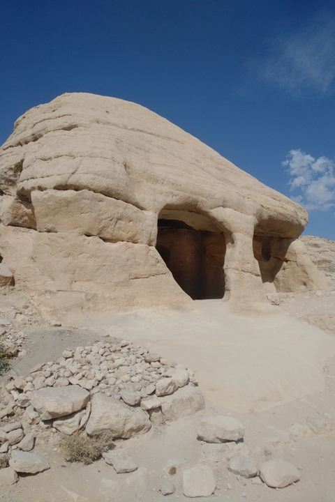 Rocky terrain with caves under a clear sky.