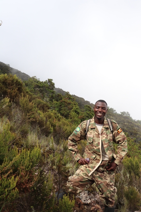       Smiling man in camouflage in a forested area.
  