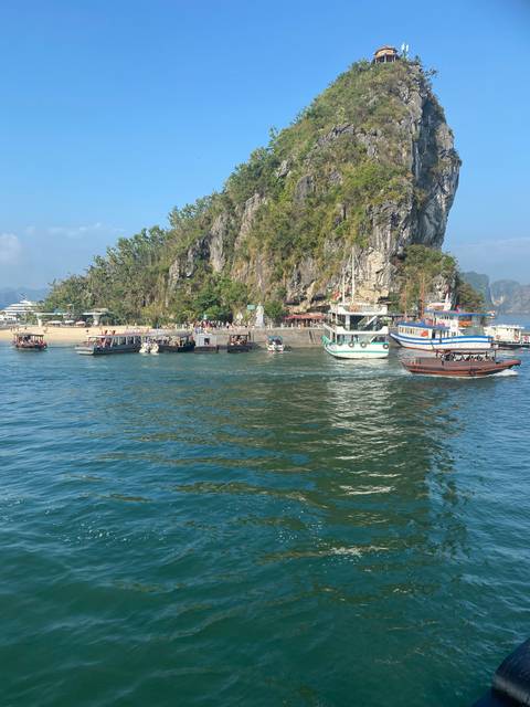       Landscape of a bay with boats and rocky cliffs.
  