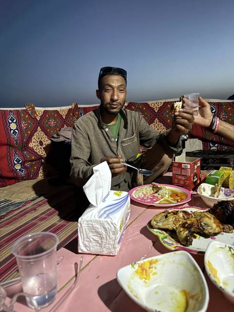       Man seated at a table with food and drinks.
  