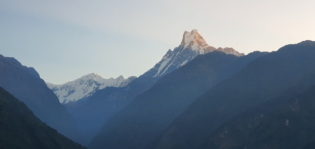Snow-capped mountain peaks during sunrise.
