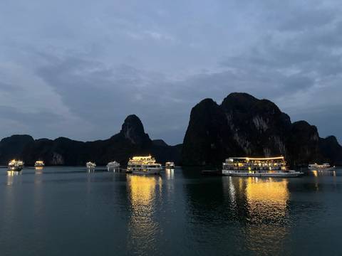Boats illuminated on Halong Bay at night.