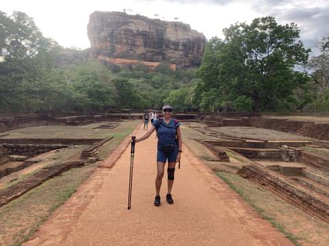       A person posing on a pathway leading to Sigiriya Rock Fortress.
  