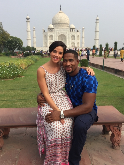 A couple sitting in a garden setting, surrounded by blooming flowers and other visitors.